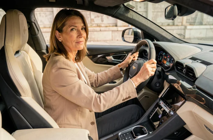 Femme au volant d'un Lamborghini Urus noir lors d'une location de voiture prestige